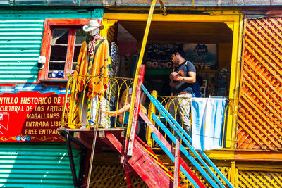 Low angle view of people on multi colored building