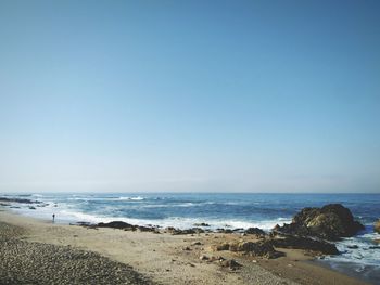 Scenic view of beach against clear blue sky