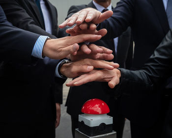 Business people stacking hands over button