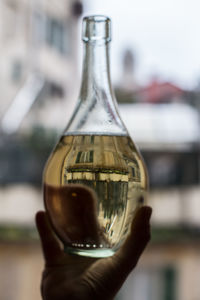 Close-up of hand holding glass bottle