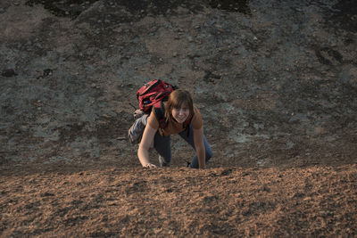 Portrait of woman climbing on rock