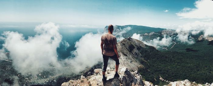 Rear view of woman standing on land against sky