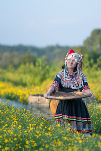 Woman with yellow flowers on field