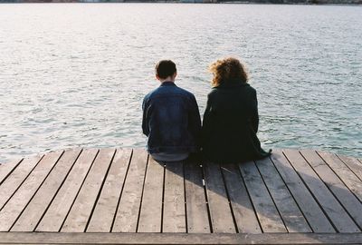 Woman sitting on pier at beach