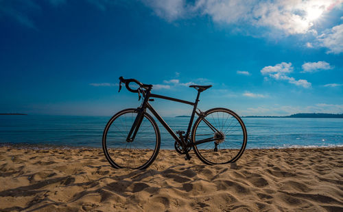 Bicycle on beach against sky