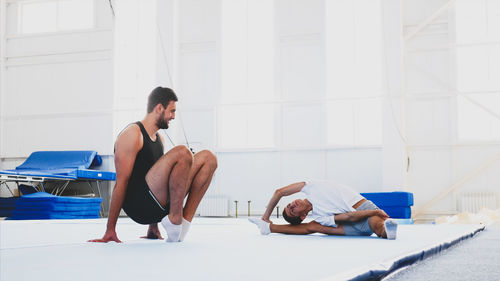 Full length of man and boy stretching