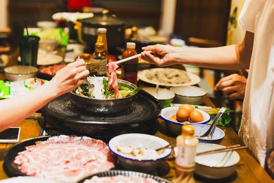 Group of friends cooking the chinese shabu hotpot at home.