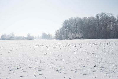 Snow covered landscape against clear sky
