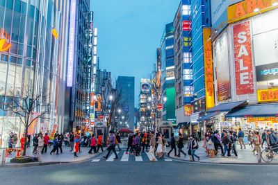 Group of people walking on road along buildings