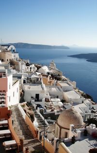 High angle view of buildings by sea against clear sky