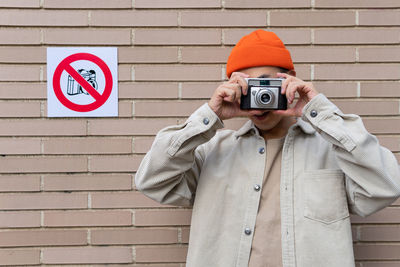 Man photographing against wall