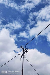 Low angle view of silhouette telephone pole against sky