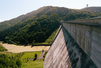 Scenic view of hydroelectric dam against mountain landscape against sky