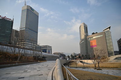 Road amidst buildings in city against sky