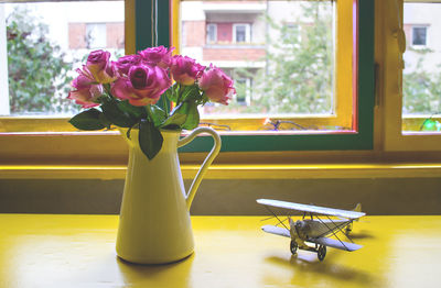Close-up of yellow flower vase on table at home