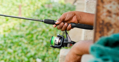 Close-up of hand holding fishing rod