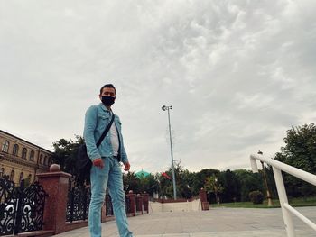 Portrait of young man standing against sky