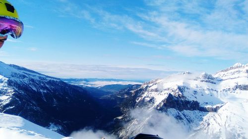 Scenic view of snow covered mountains against blue sky