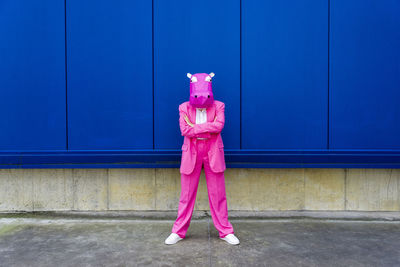 Person standing against pink wall