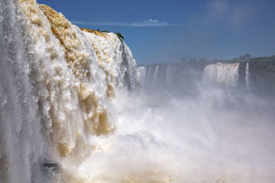 Scenic view of waterfall against sky