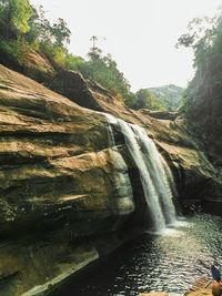 Scenic view of waterfall against sky