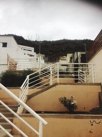 Staircase by houses against sky