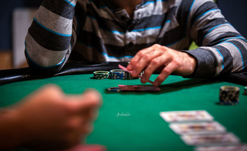 Close-up of man playing with tattoo on table