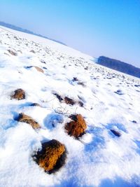 Scenic view of snow covered landscape against clear blue sky