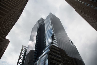 Low angle view of modern building against cloudy sky