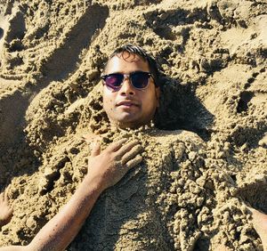 Portrait of young man wearing sunglasses at beach