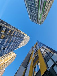 Low angle view of modern buildings against blue sky
