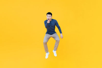 Portrait of young man against yellow background