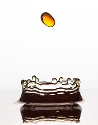 Close-up of water drops on glass against white background