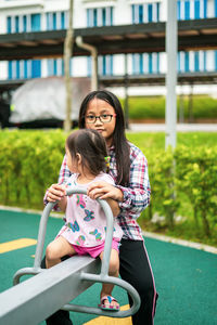 Portrait of sister playing with sibling at park