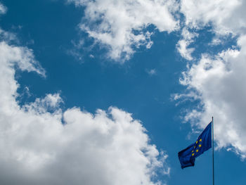 Low angle view of flag against blue sky