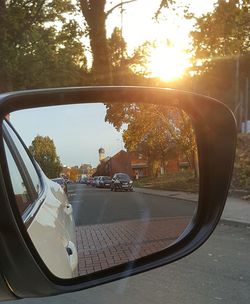 Cars on street seen through side-view mirror