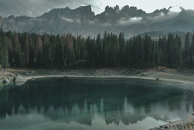 Scenic view of lake by mountains against sky