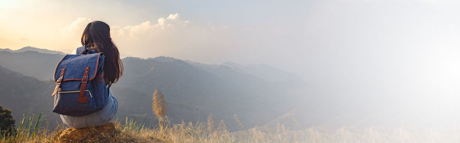 Rear view of woman looking at mountain range against sky