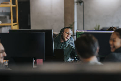 Smiling male and female programmers working on computer at startup company