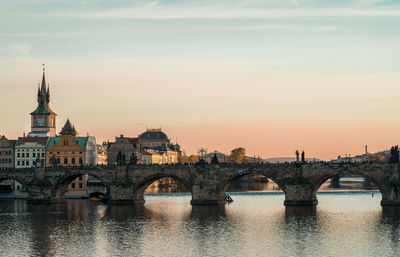 Bridge over river against buildings in city