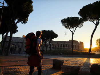 Man walking in city during sunset