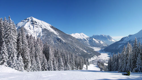 Scenic view of snowcapped mountains against clear blue sky
