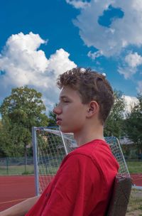 Side view of boy looking away against sky