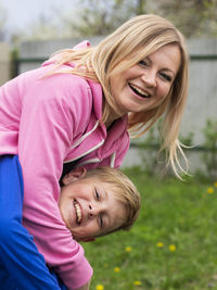 Portrait of smiling woman with son at yard