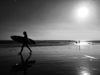 Silhouette man on beach against sky