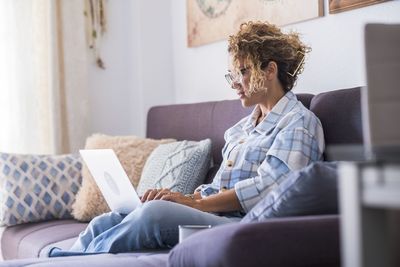 Woman sitting on sofa at home