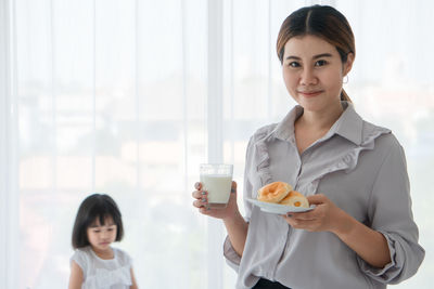 Portrait of a smiling young woman holding drink