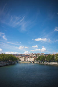 River amidst buildings in city against sky