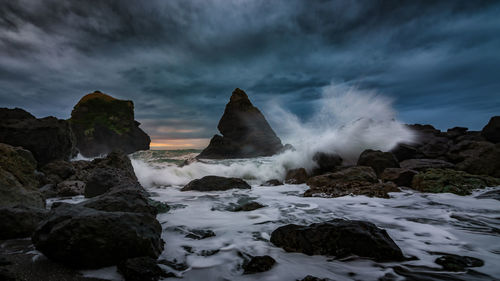 Scenic view of rocks in sea against sky