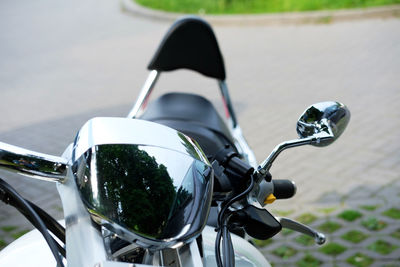 Closeup of a classic motorcycle handlbar and chrome headlight and mirror.